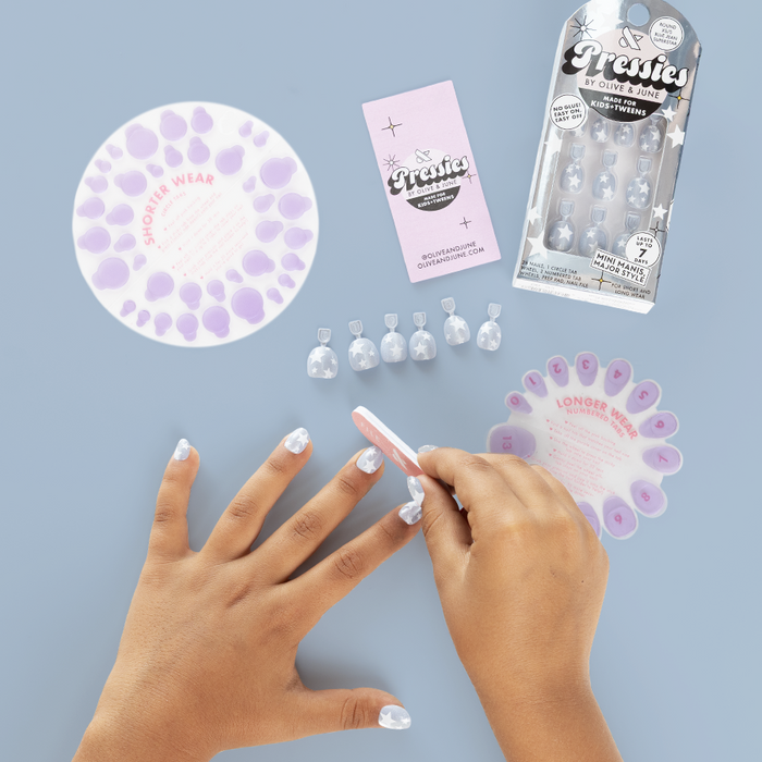Blue Jean Superstar - Pressies | Extra Short Short | Round showing kid filing nails with shimmery blue press on nails and white stars