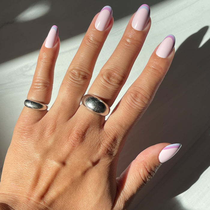 Double French - Press-On | Medium | Oval showing medium oval press-on nails with dual pastel pink french tip manicure on hand