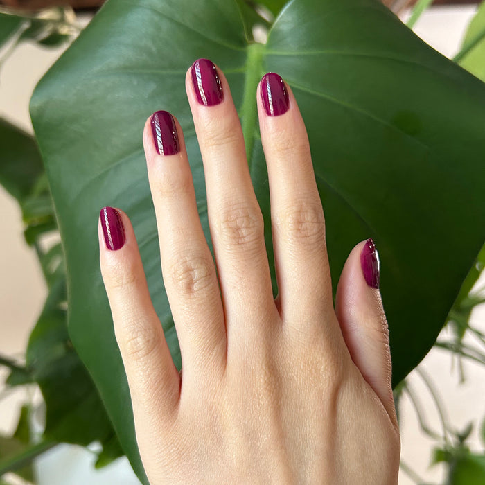 Plaza - Gel polish on nails in a deep mulberry purple shade for a sleek, long-lasting mani by Olive and June