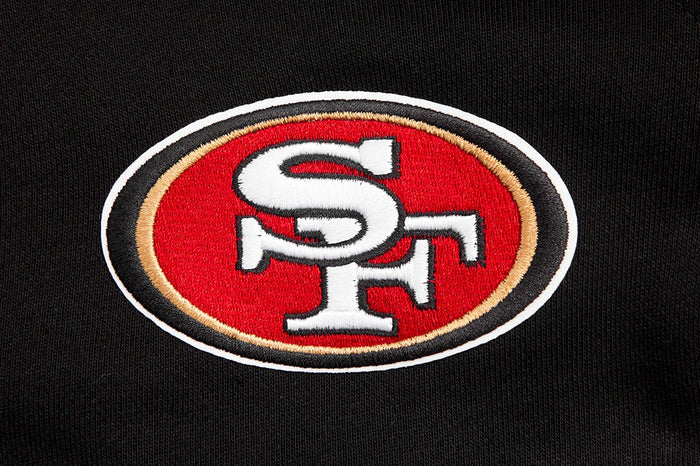 Detail shot of the San Francisco 49ers logo and Wingspan design on the front of the black crewneck