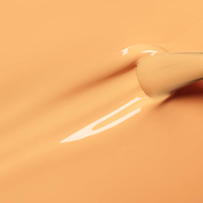 A close-up of a Manucurist Abricot brush spreading creamy pastel orange nail polish, creating smooth, glossy streaks on a matching background.