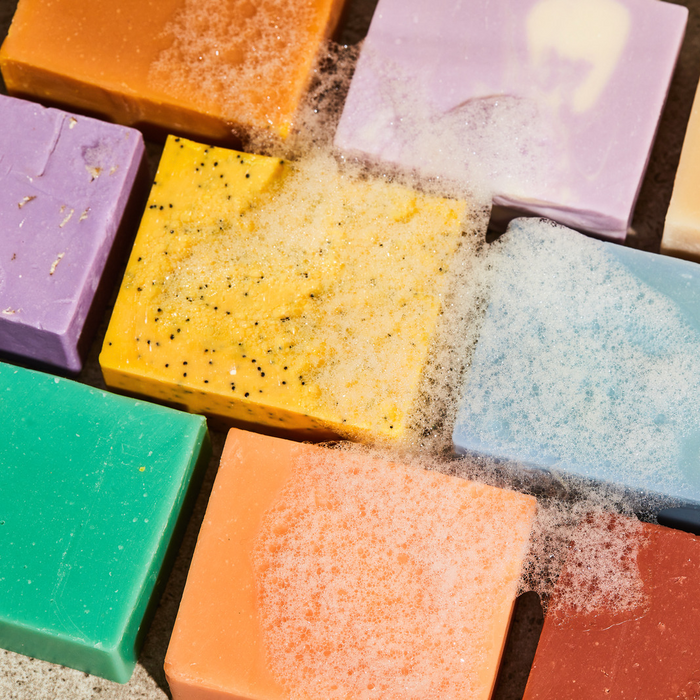 Assorted bar soaps with colorful bars and visible suds and texture on top.