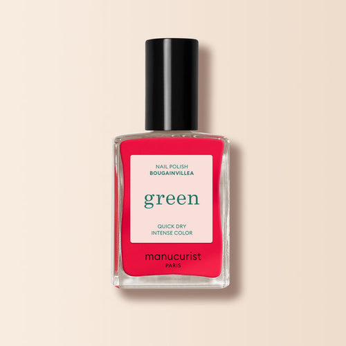 A bottle of Manucurist Bougainvillea—a bright reddish pink nail polish with a black cap and white label reading "green, quick dry intense color, and nail polish.