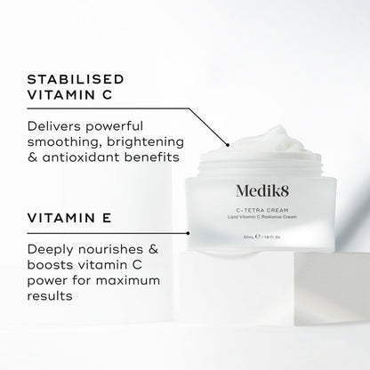 Medik8 C-Tetra Cream jar displayed open on a white stone block against a clean white background. The image features two key ingredients and their benefits:

STABILISED VITAMIN C: Delivers powerful smoothing, brightening, and antioxidant benefits.

VITAMIN E: Deeply nourishes and boosts vitamin C power for maximum results.