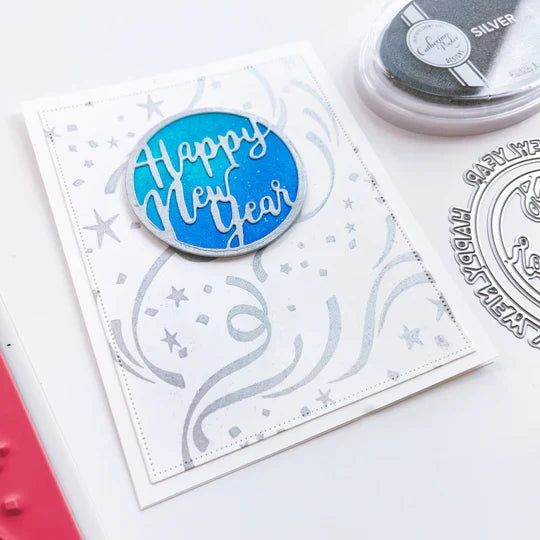 Catherine Pooler - Die - Round of New Year. Add a New Year's greeting with the Round of New Year Dies. This pair of circle word dies can be used together or separately. Layer them with the Circle Dies for festive shaker options. Available at Embellish Away located in Bowmanville Ontario Canada. Example by brand ambassador.