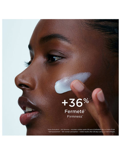 Clarins Precious La Crème Bright 50ml jar of luxurious skincare cream with a gold lid, displayed on a reflective surface.