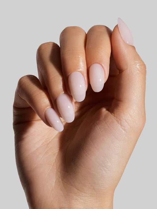 Close-up of a hand with Coconut Milk  press-on nails on a neutral background
