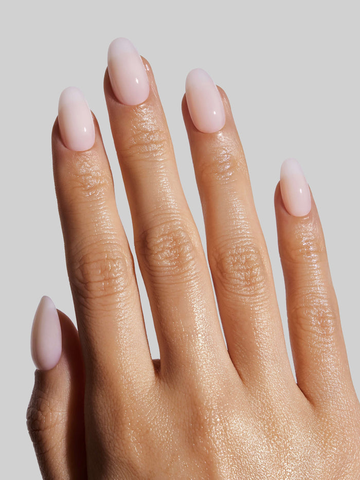 Close-up of a hand with Coconut Milk  press-on nails on a neutral background