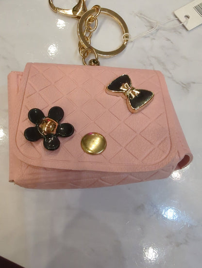 Josslyn designer bag charm keychain with decorative charms and metallic accents hanging from a luxury purse strap.