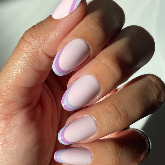 Double French - Press-On | Medium | Oval showing medium oval false nails with two-tone pastel french tip manicure on hand