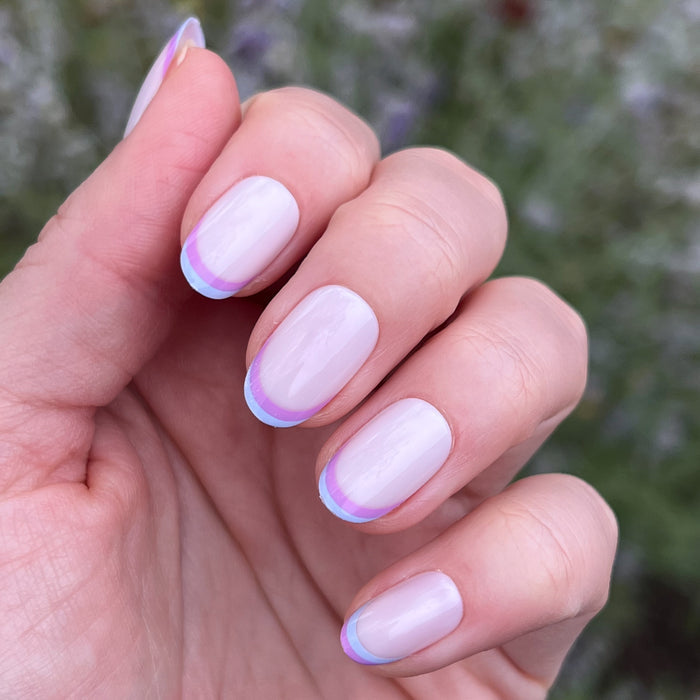 Double French - Press-On | Medium | Oval showing medium oval false nails with dual pastel french tip manicure on hand