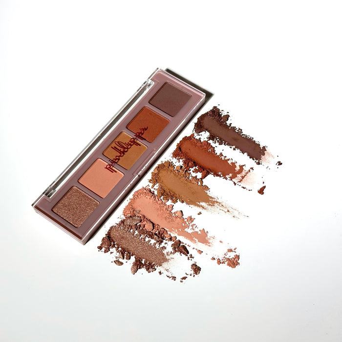 Swatch of Pink Lipps Fall Sweet Fall Eyeshadow Palette shades smeared on white background showing warm bronze, golden, and caramel-matte finishes