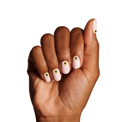 Hand with pale pink gel polish and Feeling Groovy sunflower nail art stickers by Olive and June for stylish mani