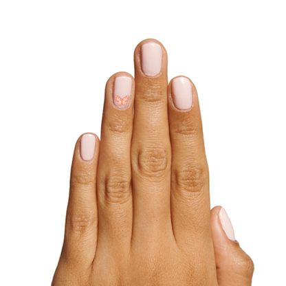 Hand with soft pink gel polish and small butterfly nail art sticker from Feeling Groovy pack by Olive and June