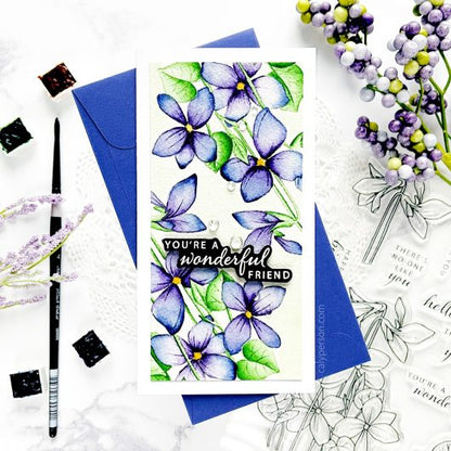 Gina K. Designs - Stamp & Die Set - Blue Violets. Blue Violet is a stamp set by Arjita Singh. This set is made of premium clear photopolymer and measures 6" X 8". The die set gives you the ability to cut out and layer, creating texture to your creation. Available at Embellish Away located in Bowmanville Ontario Canada. Example by brand ambassador.