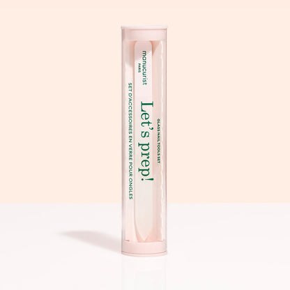 A cylindrical, clear container with a pink lid and base holds the Glass nail accessory trio by Manucurist-us. The label says "Lets prep!" and "manucurist Paris," with text in English and French.