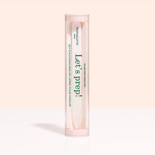 A cylindrical, clear container with a pink lid and base holds the Glass nail accessory trio by Manucurist-us. The label says "Lets prep!" and "manucurist Paris," with text in English and French.