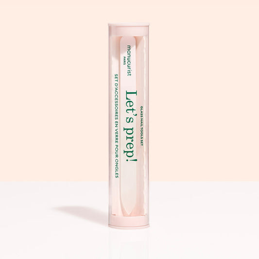 A cylindrical, clear container with a pink lid and base holds the Glass nail accessory trio by Manucurist-us. The label says "Lets prep!" and "manucurist Paris," with text in English and French.