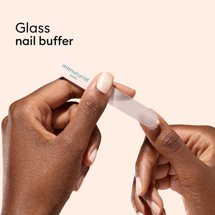 A close-up of a person filing their nails with the Glass nail accessory trio by Manucurist-us.
