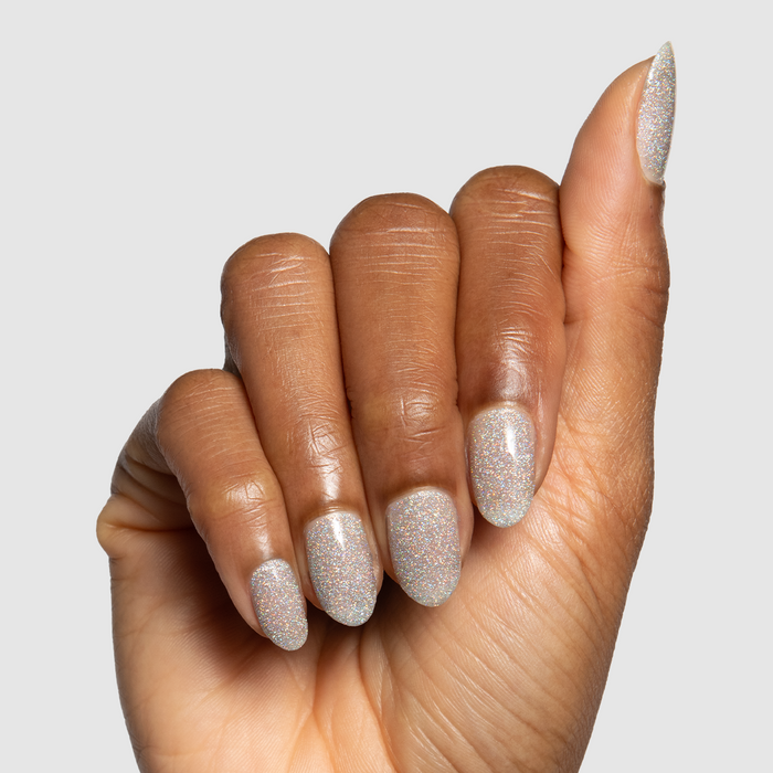 Glitter Department Gel on almond-shaped nails with holographic silver sparkle for a festive at-home manicure