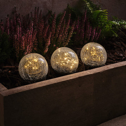 3 crackle glass solar stake lights in a planter