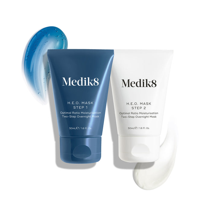 The two tubes of Medik8 H.E.O. Mask are displayed: a blue tube for Step 1 with a blue gel swatch, and a white tube for Step 2 with a white cream swatch.