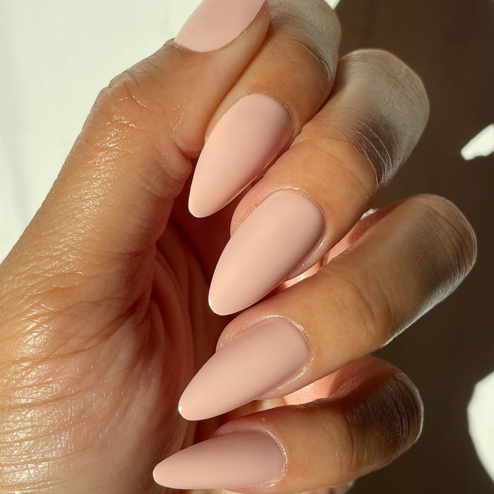 KAG - Press-On | Long | Almond showing hand with long almond false nails in soft neutral peachy pink mani polish