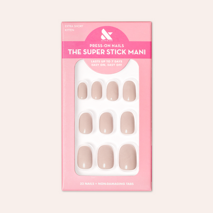Kitten | Extra Short | Round - Tab Press-On showing neutral grey beige false nails in pink packaging against pale background