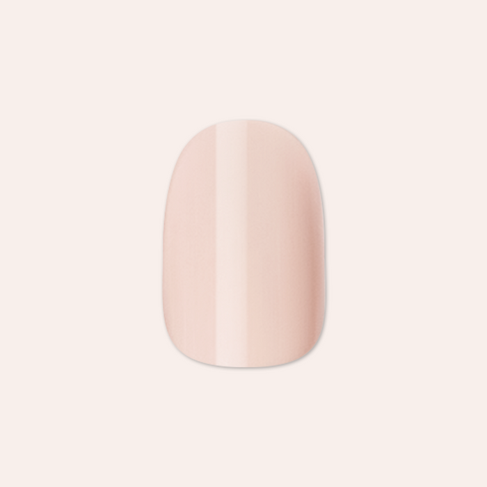 Kitten | Extra Short | Round - Tab Press-On showing a soft neutral beige false nail with glossy finish on pale background