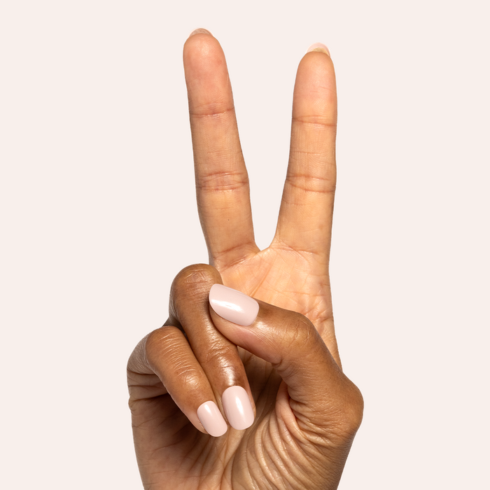 Kitten | Extra Short | Round - Tab Press-On showing neutral grey beige press-on nails on hand against light background