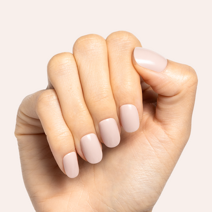 Kitten | Extra Short | Round - Tab Press-On showing soft neutral grey beige false nails on hand against pale background
