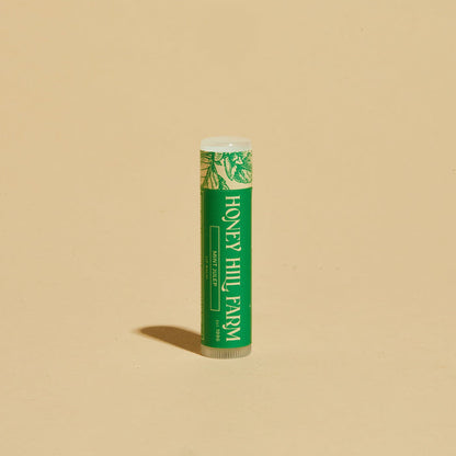 Lip balm tube with green label and white cap