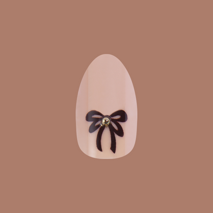 Little Gem Bows - Press On | Medium | Almond nail with creamy beige base and black bow with a 3D gem for an at-home mani
