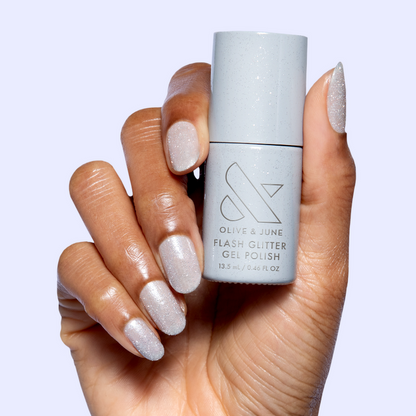Mani on the Dance Floor Gel on natural nails held with bottle showing silver glitter gel polish for long-lasting manicure