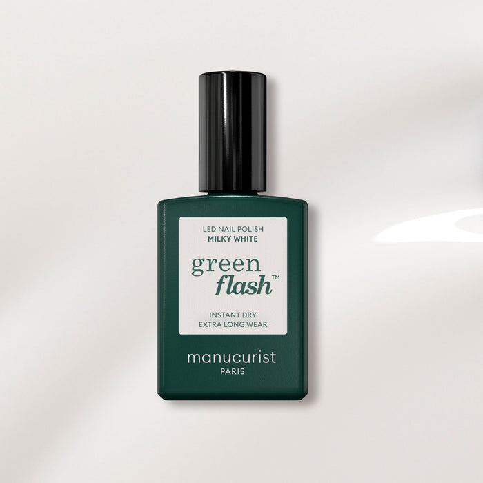 A bottle of Manucurist Milky White gel polish with a dark green rectangular base and black cap, displayed against a light background.
