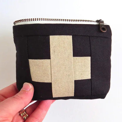 Mini first aid kit pouch in black fabric with cream patchwork cross and top zipper