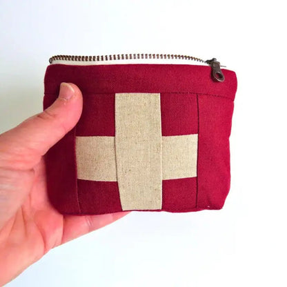 Mini first aid kit pouch in burgundy fabric with cream patchwork cross and top zipper