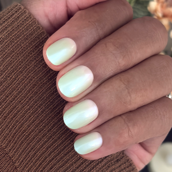 Hand with Minty Shimmer | Extra Short | Round - Tab Press-On nails in soft mint green gradient with subtle shimmer finish