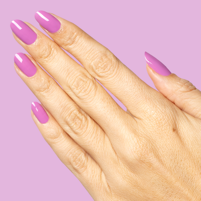 Hand with glossy nails painted in bright floral purple shade using Petal - Gel on matching purple background