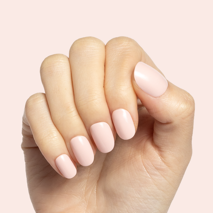 Pointe | Extra Short | Round - Tab Press-On soft ballerina pink press-on nails shown on hand with pale pink background
