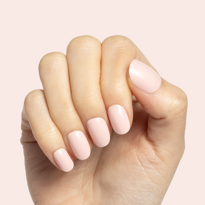 Pointe | Extra Short | Round - Tab Press-On soft ballerina pink press-on nails shown on hand with pale pink background