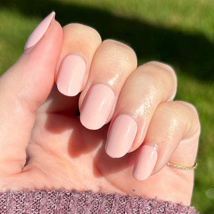 Pointe | Extra Short | Round - Tab Press-On soft ballerina pink manicure on hand shown in natural sunlight outdoors