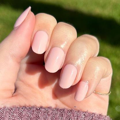 Pointe | Extra Short | Round - Tab Press-On soft ballerina pink manicure on hand shown in natural sunlight outdoors