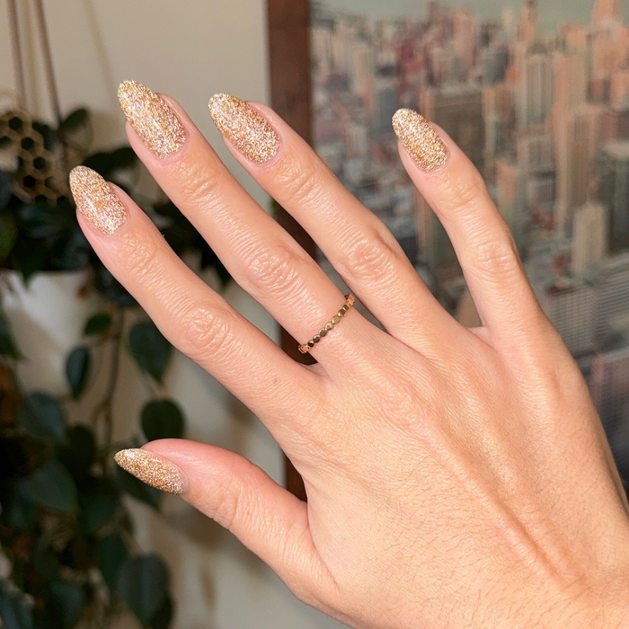 Pop Fizz Mani Gel applied on nails showing sparkly yellow gold glitter for a festive at-home manicure look
