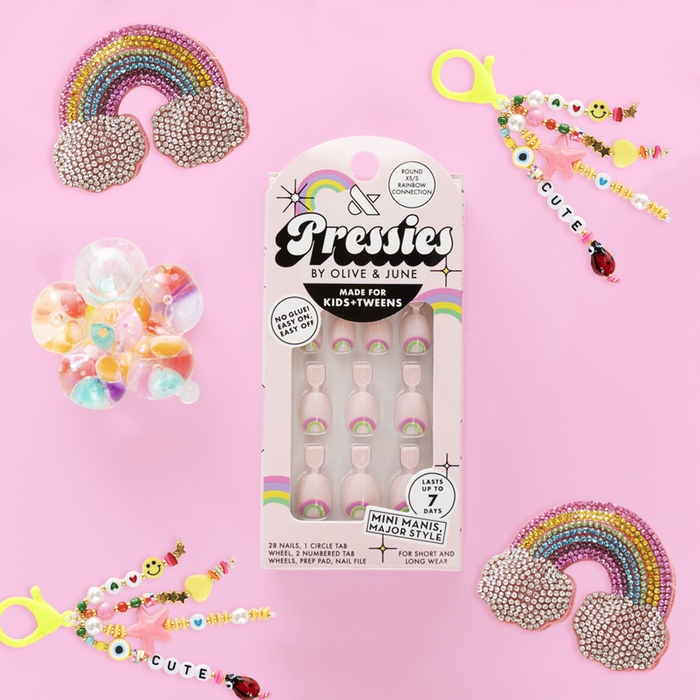 Rainbow Connection - Pressies | Extra Short Short | Round showing pastel pink press on nails with rainbow accents in packaging on pink background