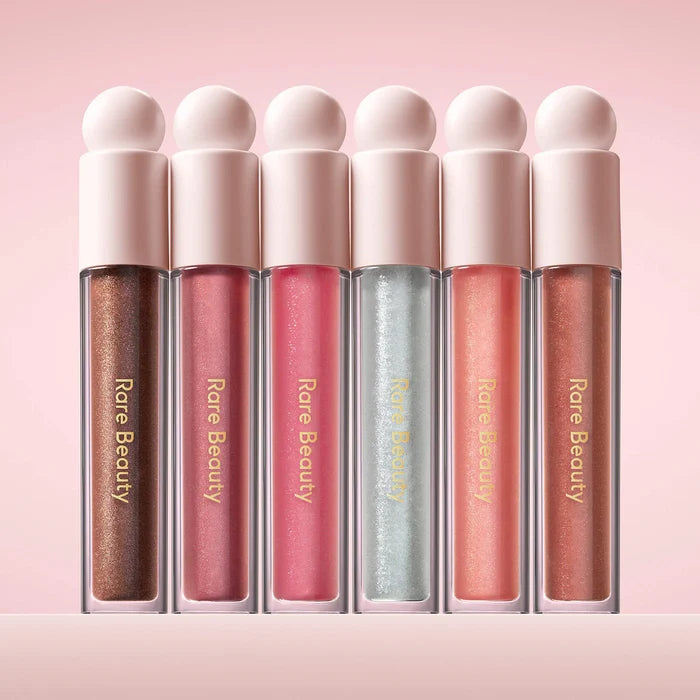 Rare Beauty Positive Light Luminizing Lip Gloss in various shades, featuring glossy, radiant finish and smooth application.