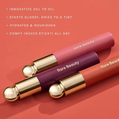 Rare Beauty Soft Pinch Tinted Lip Oil in various shades, featuring a sleek applicator and vibrant, glossy lip stain.