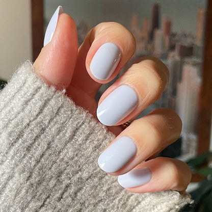 Rink | Short | Round - Tab Press-On glossy icy blue press-on nails on hand wearing gray knit sweater indoors