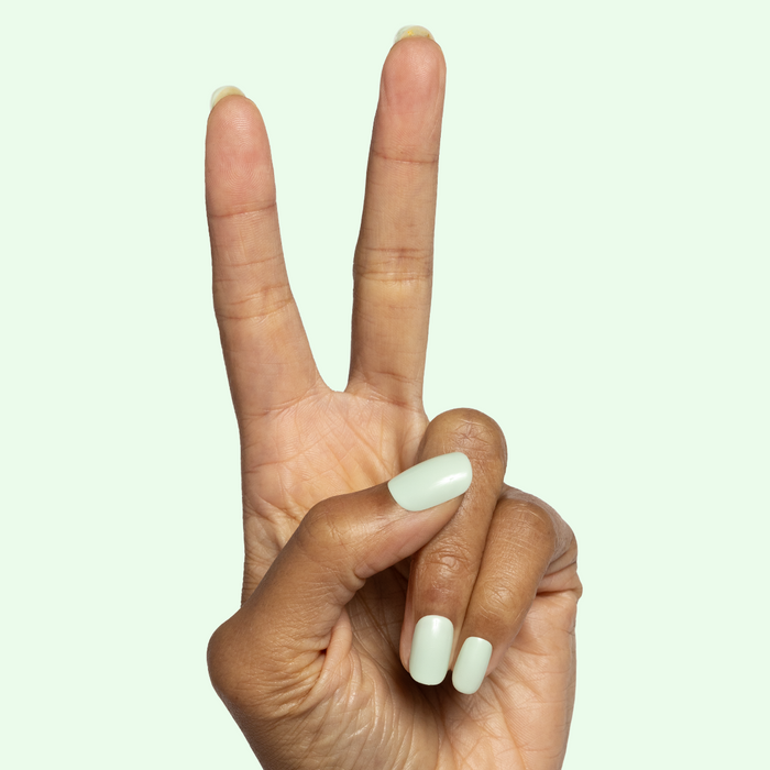 Seafoam | Short | Squoval - Tab Press-On soft pastel green false nails on hand showing peace sign gesture