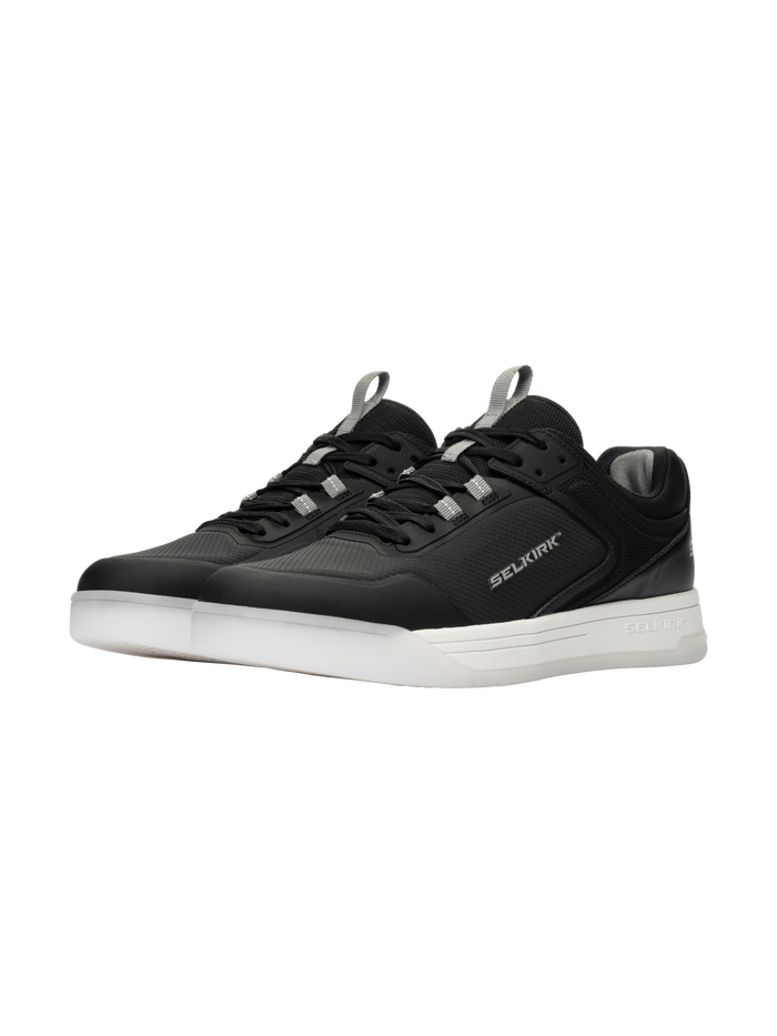 Three-quarter view of Selkirk Legacy Pro pickleball shoes with InfiniGrip, black uppers, white soles, and Selkirk branding